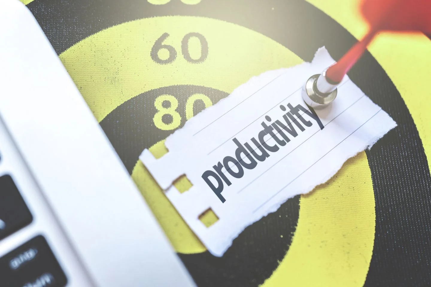 note reading "productivity" stuck to a dartboard