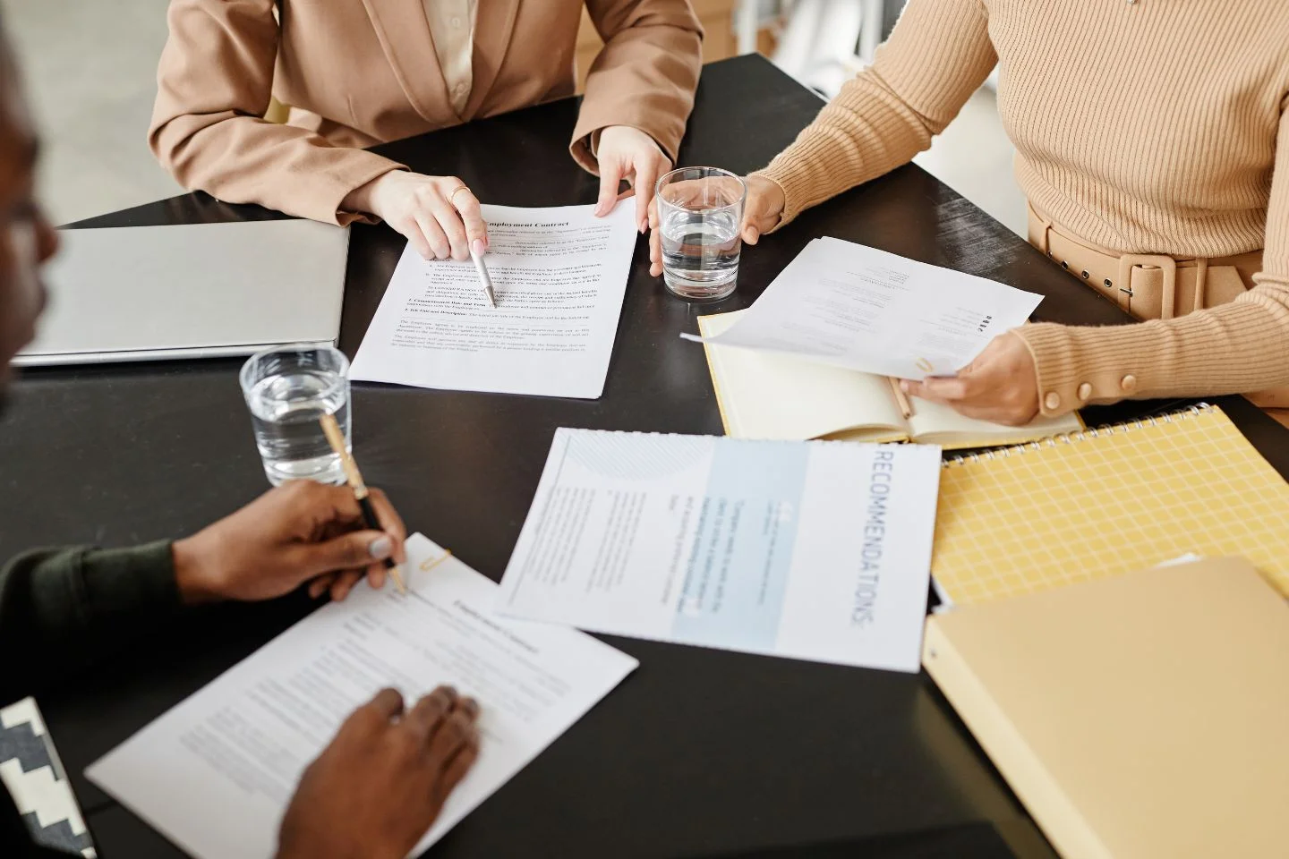 people sitting at a table, reading papers