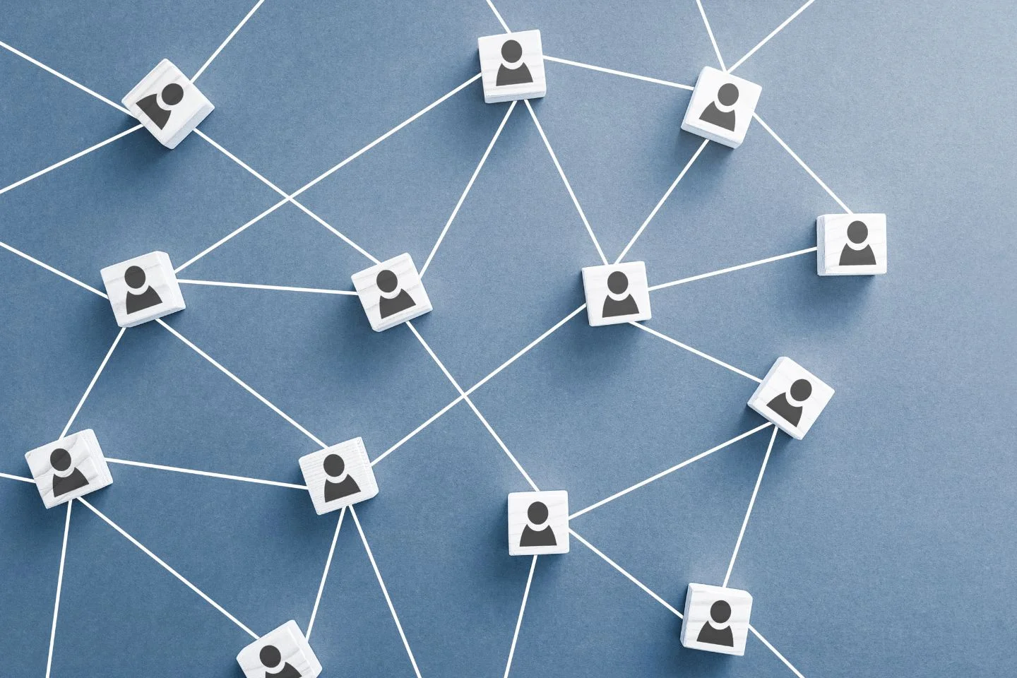 a line-drawn web connecting small wooden cubes with user icons printed on them