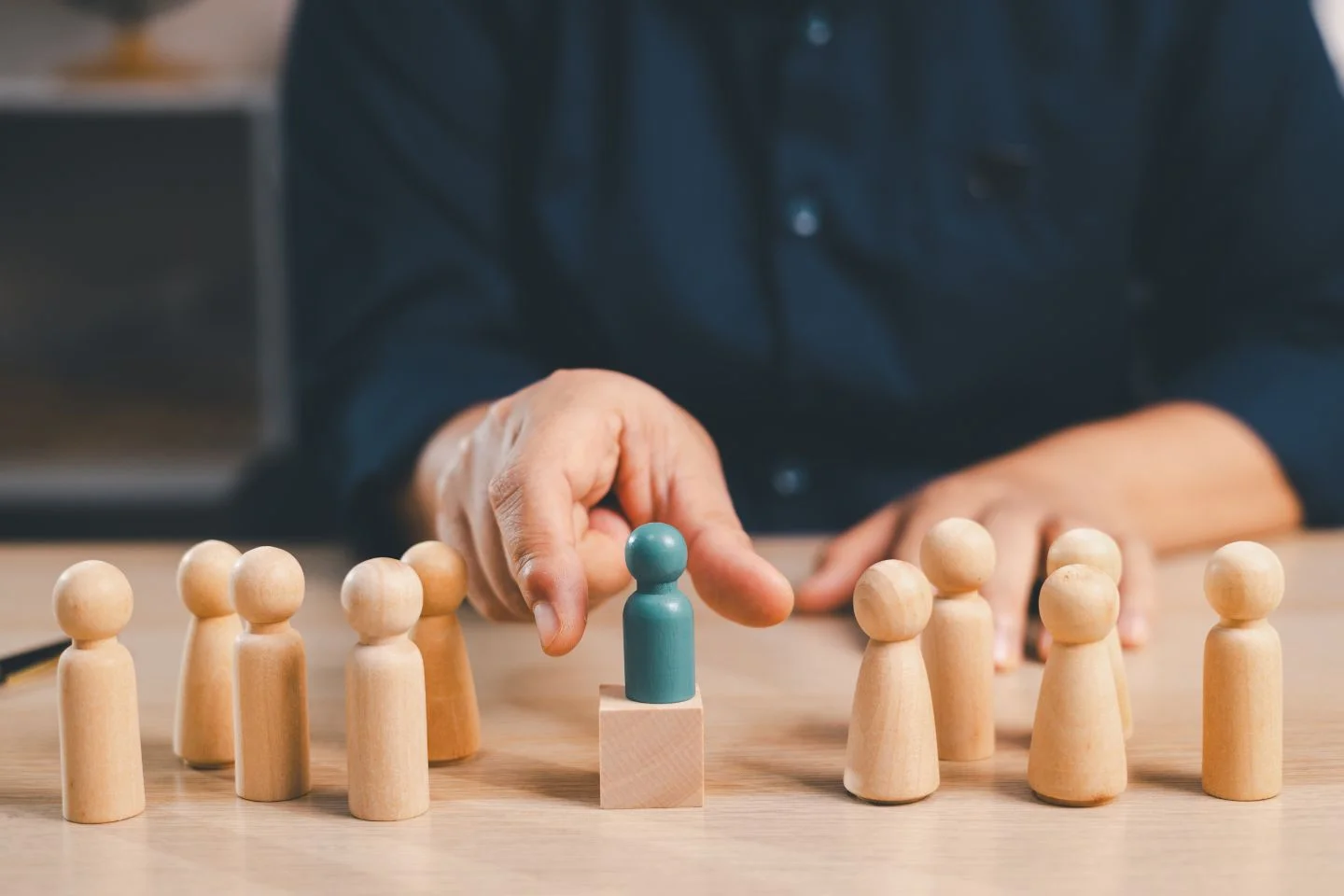 person reaching for a person-shaped wooden piece